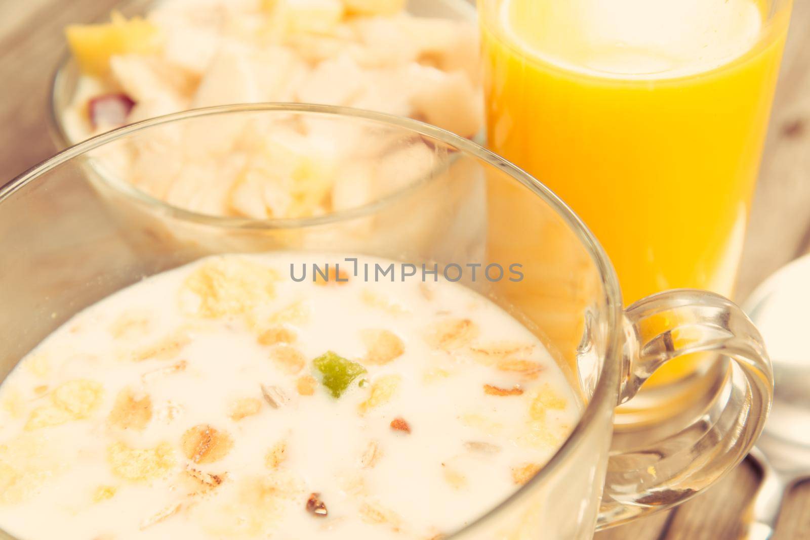Oatmeal with milk and fruit salad for breakfast on a wooden table, space for text