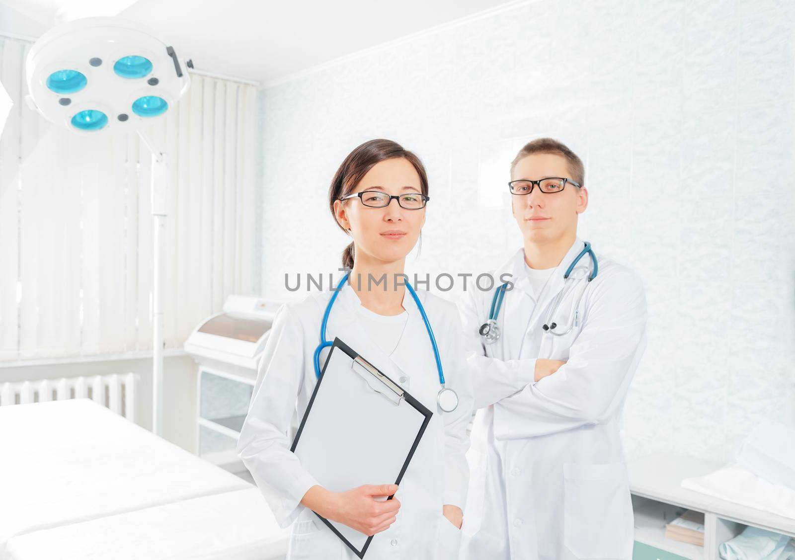 Two young practitioners doctors in a surgical room