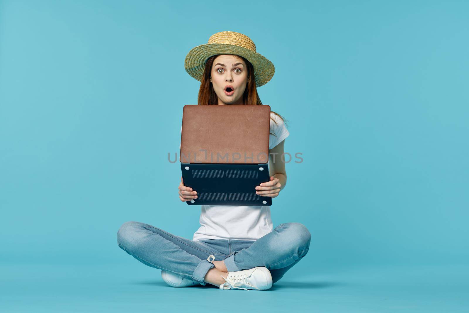 woman with laptop learning internet online education blue background. High quality photo