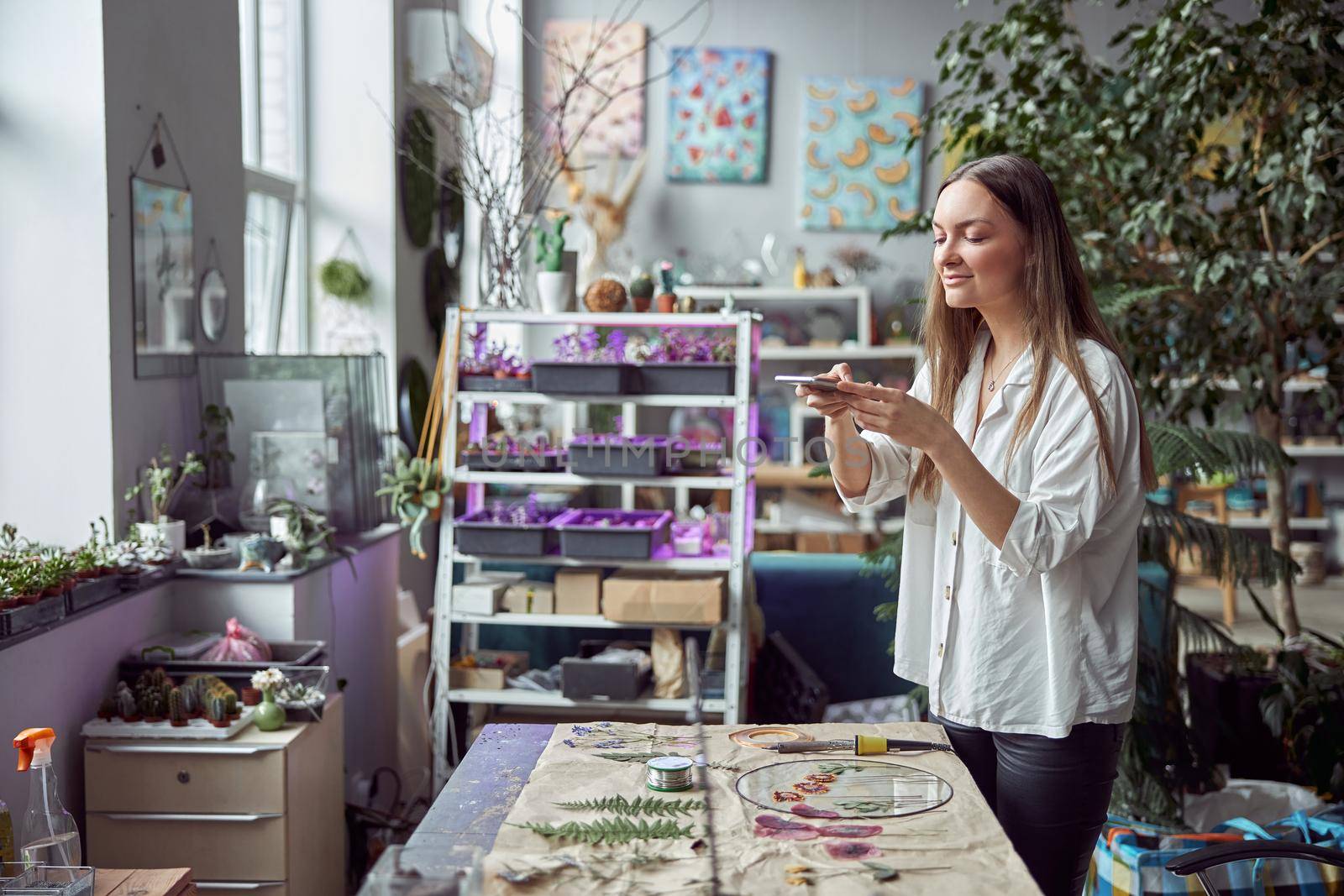 Confident female florist is working with dryed flowers in cozy flower shop