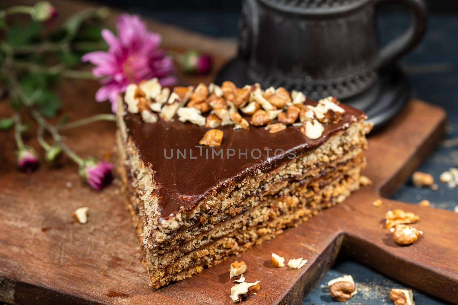 Piece of cake with walnuts on a dark wood background