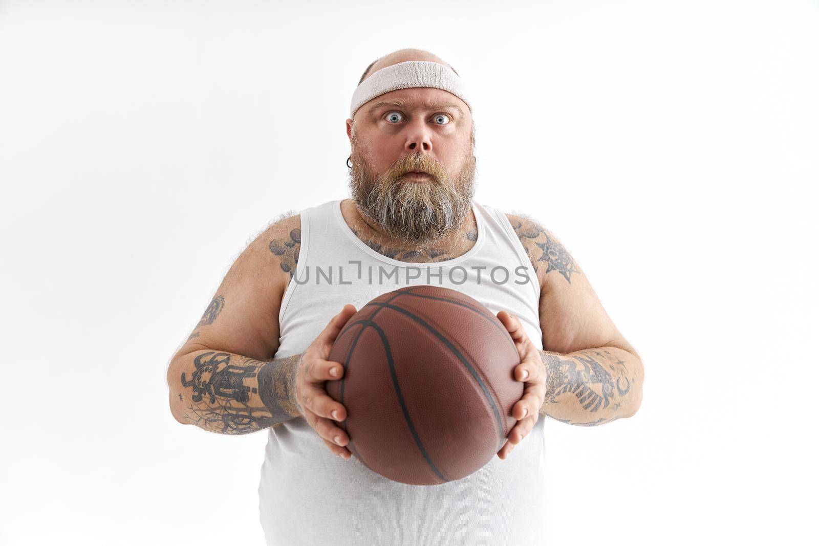 bearded fat caucasian tattoed man with basketball ball in white background. He is funny and happy by Yaroslav_astakhov