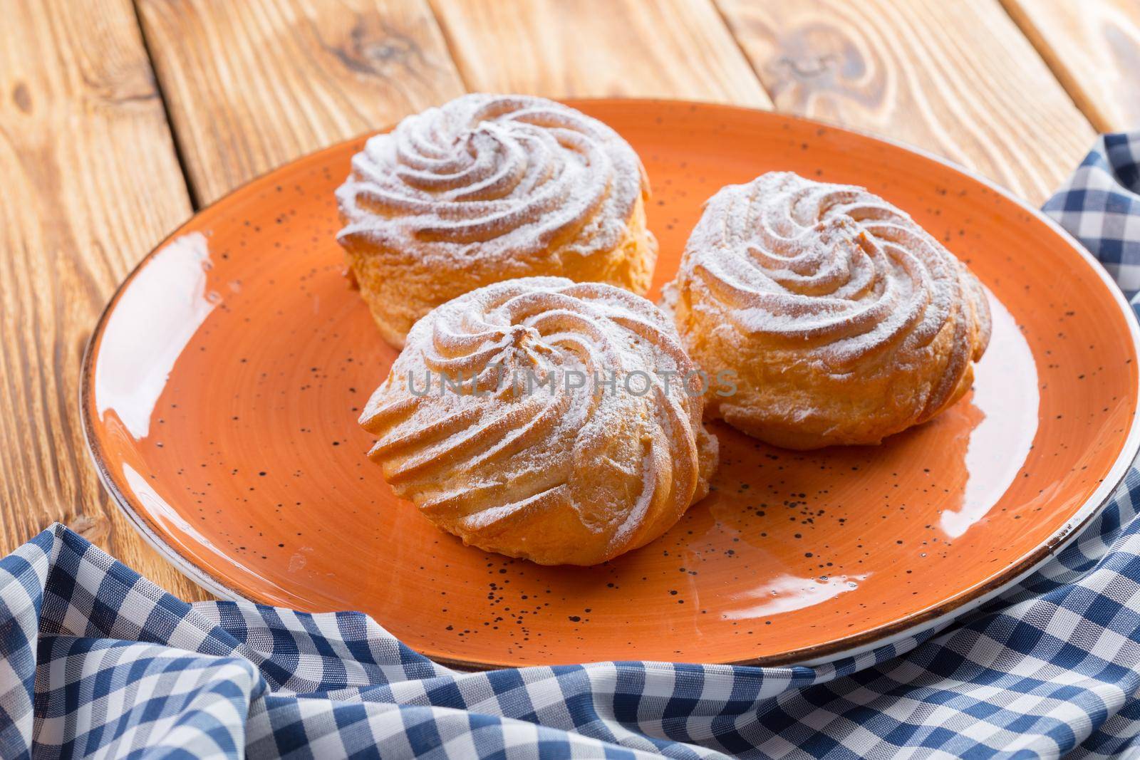 Small french cookies profitroles with sugar powder close up