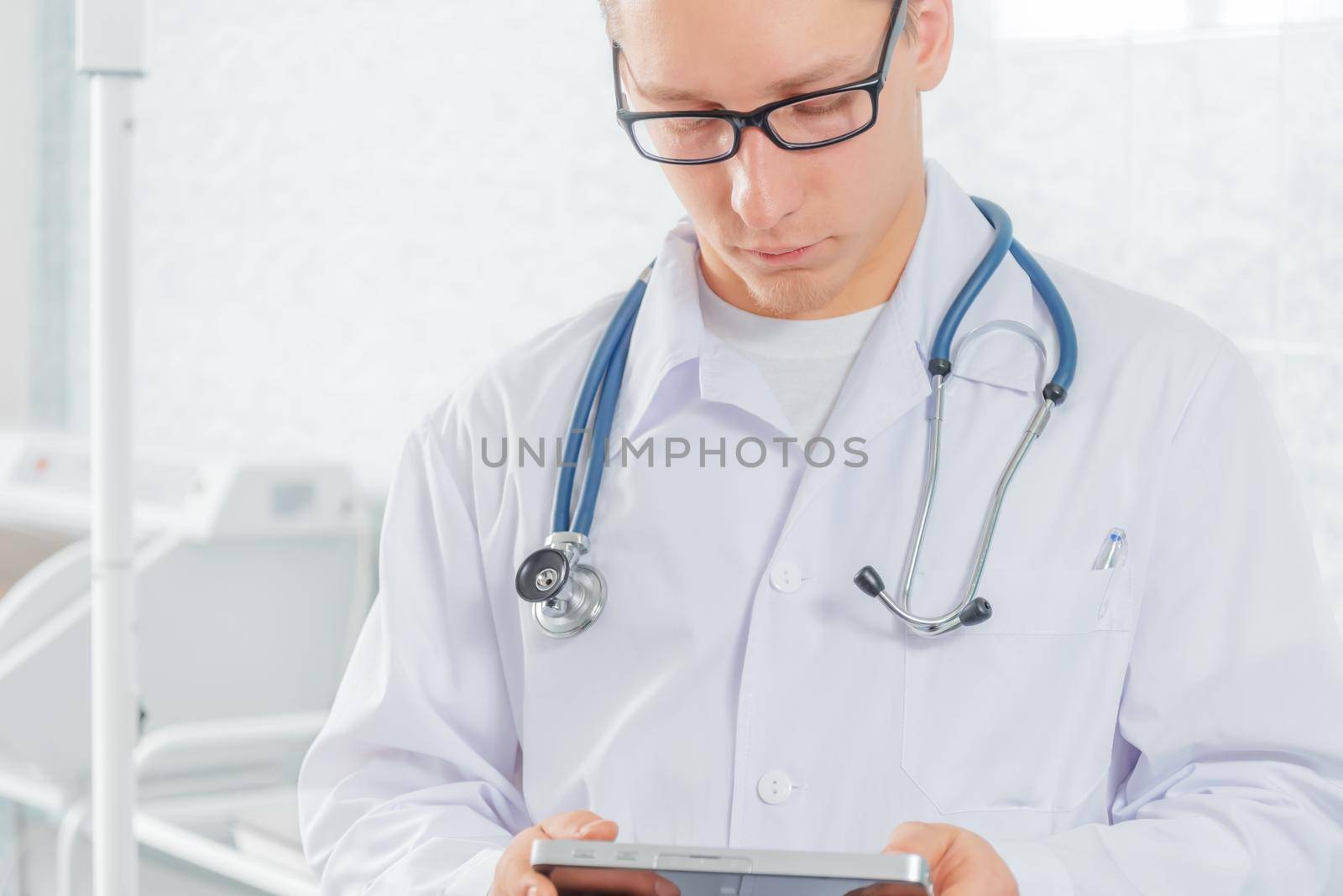 Man doctor works on a tablet computer in hospital