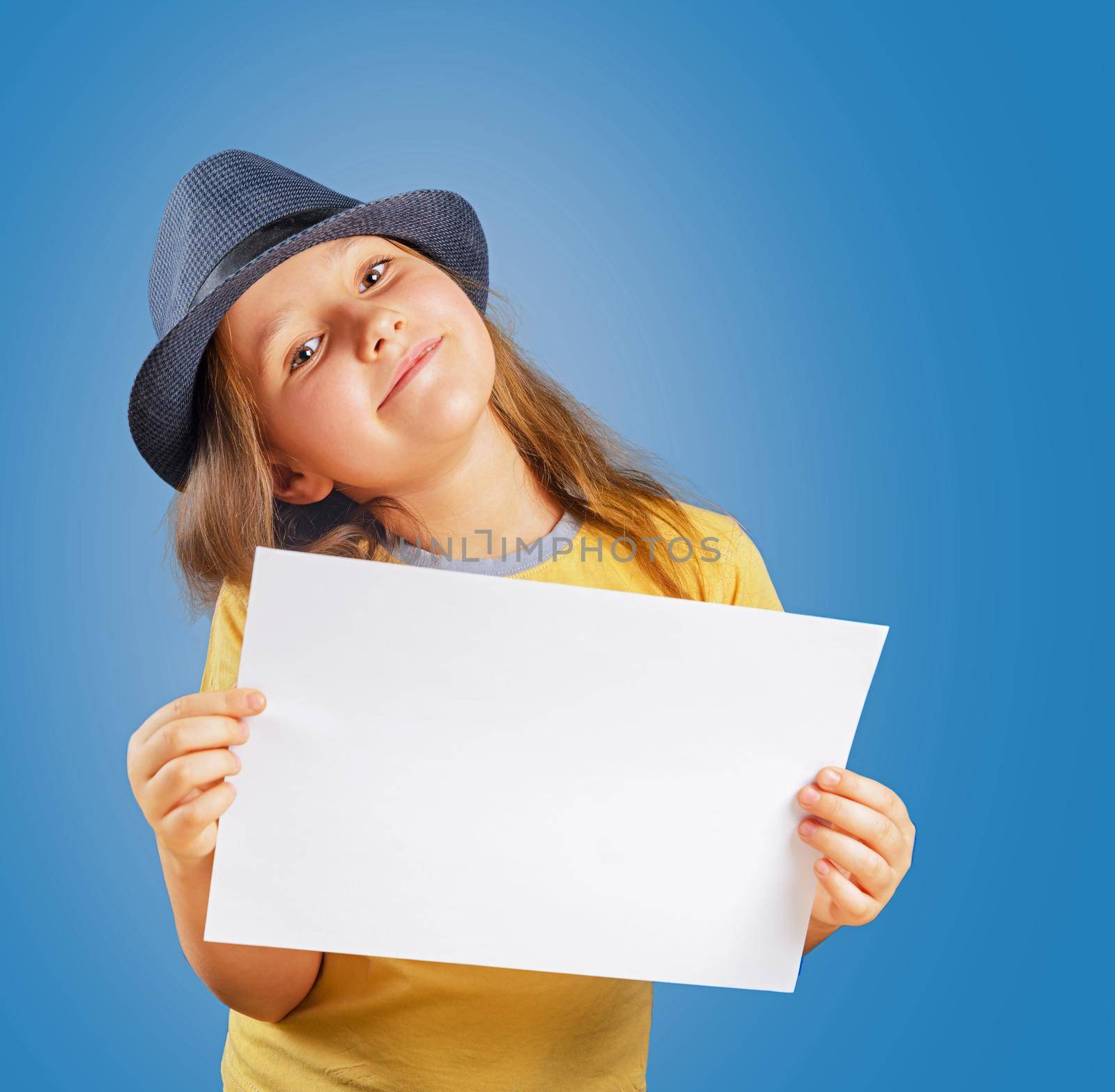 Happy little girl holds empty paper, space for text