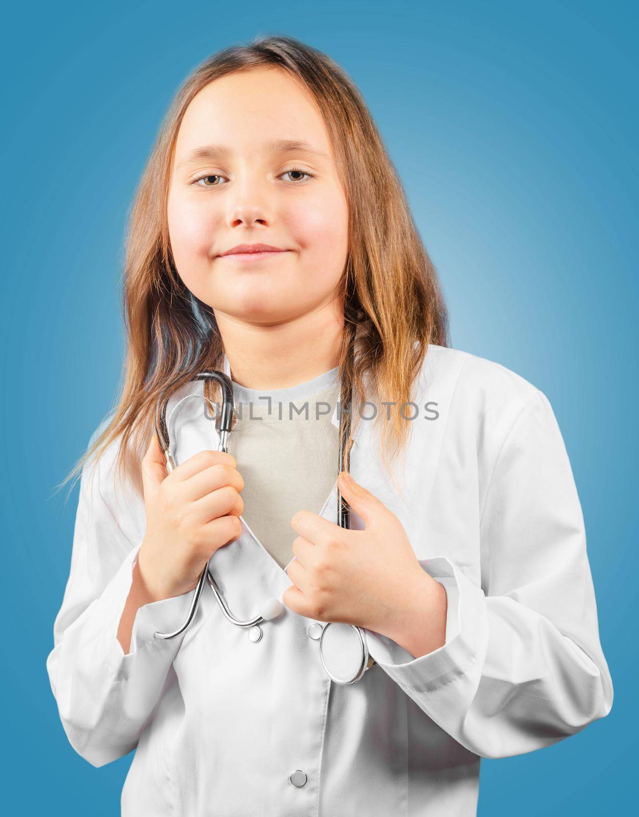 Happy little girl in medical uniform with stethoscope, concept of future profession