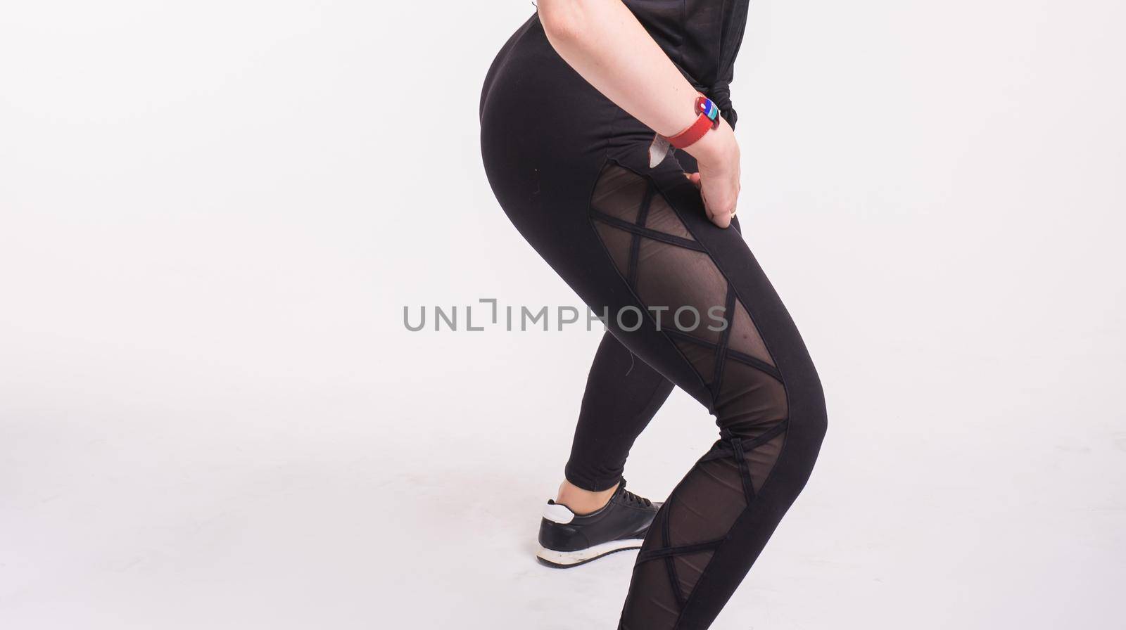 Close-up of girl dancing twerk in the dance class on white background.