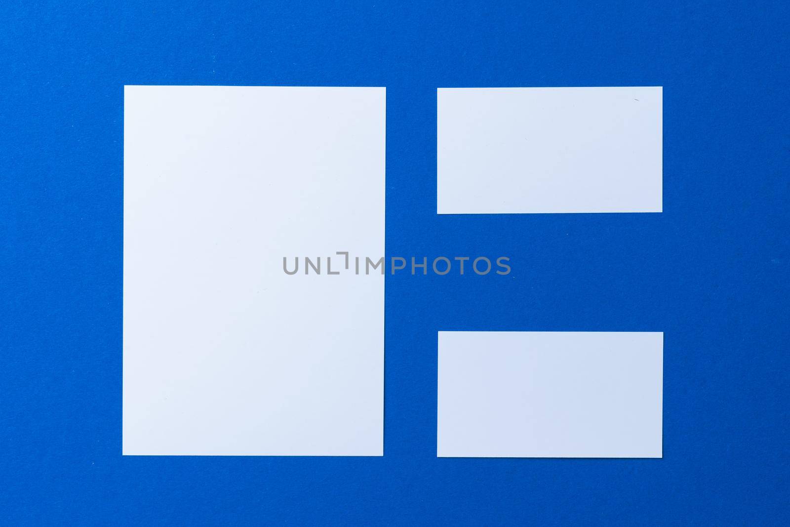 Blank paper business mock up on classic blue background, top view