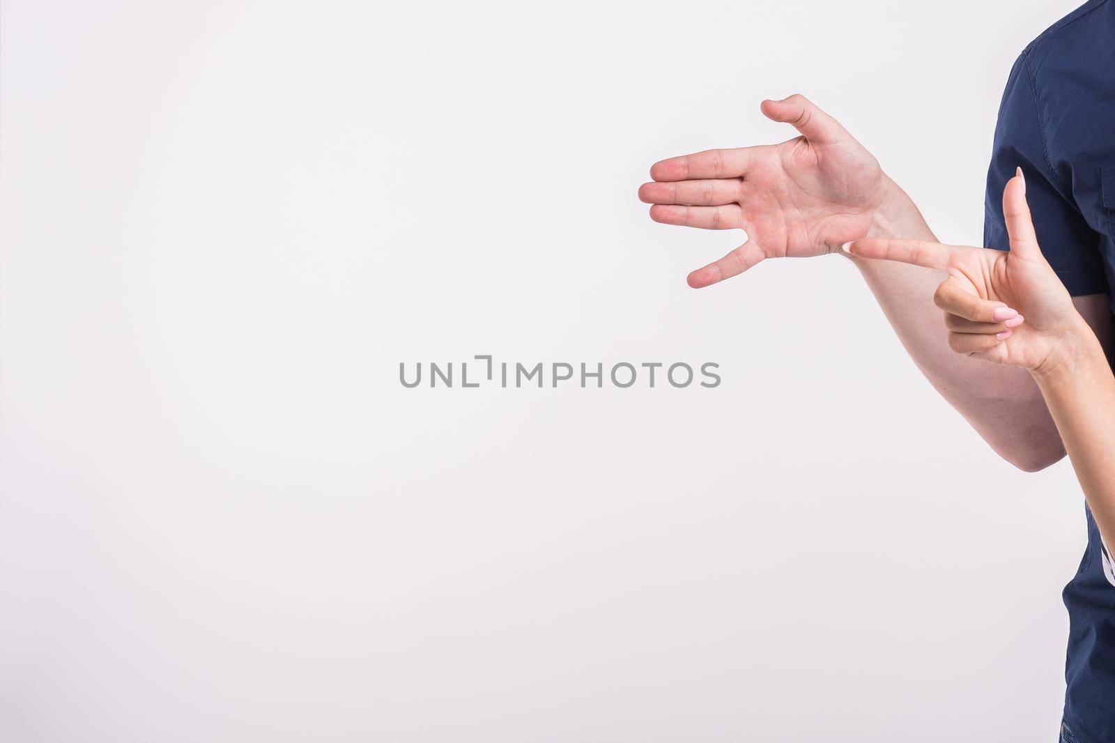 Couple pointing at the left corner with fingers standing isolated over white background. Copy space for product advertisement. by Satura86