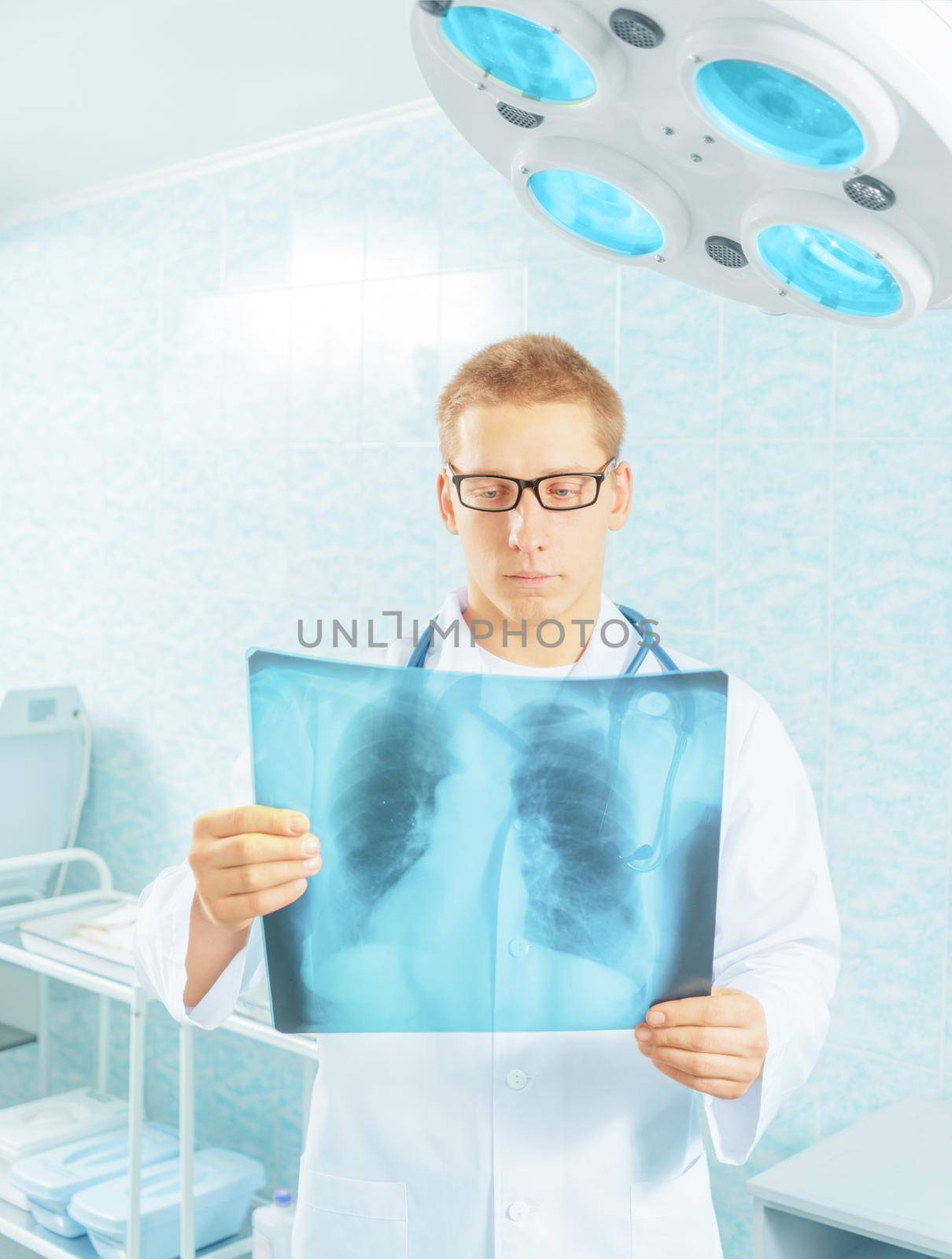 Man physician examines x-ray picture of lungs in a hospital