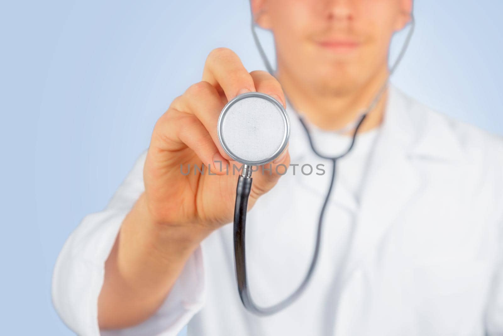 Man doctor listens with stethoscope something in the air, space for text