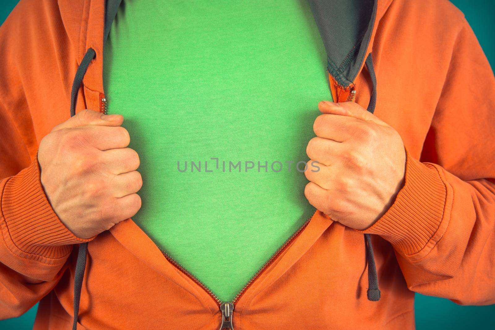 Unrecognizable man opens shirt showing green t-shirt, space for text