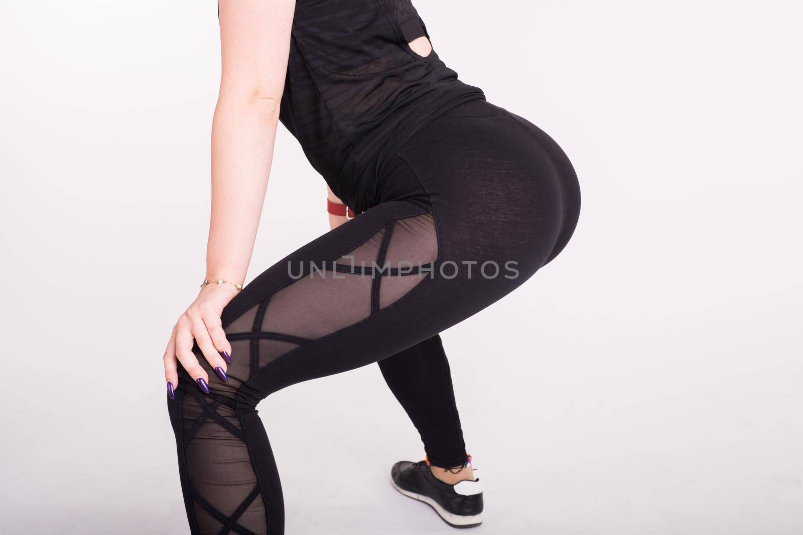 Close-up of girl dancing twerk in the dance class on white background.