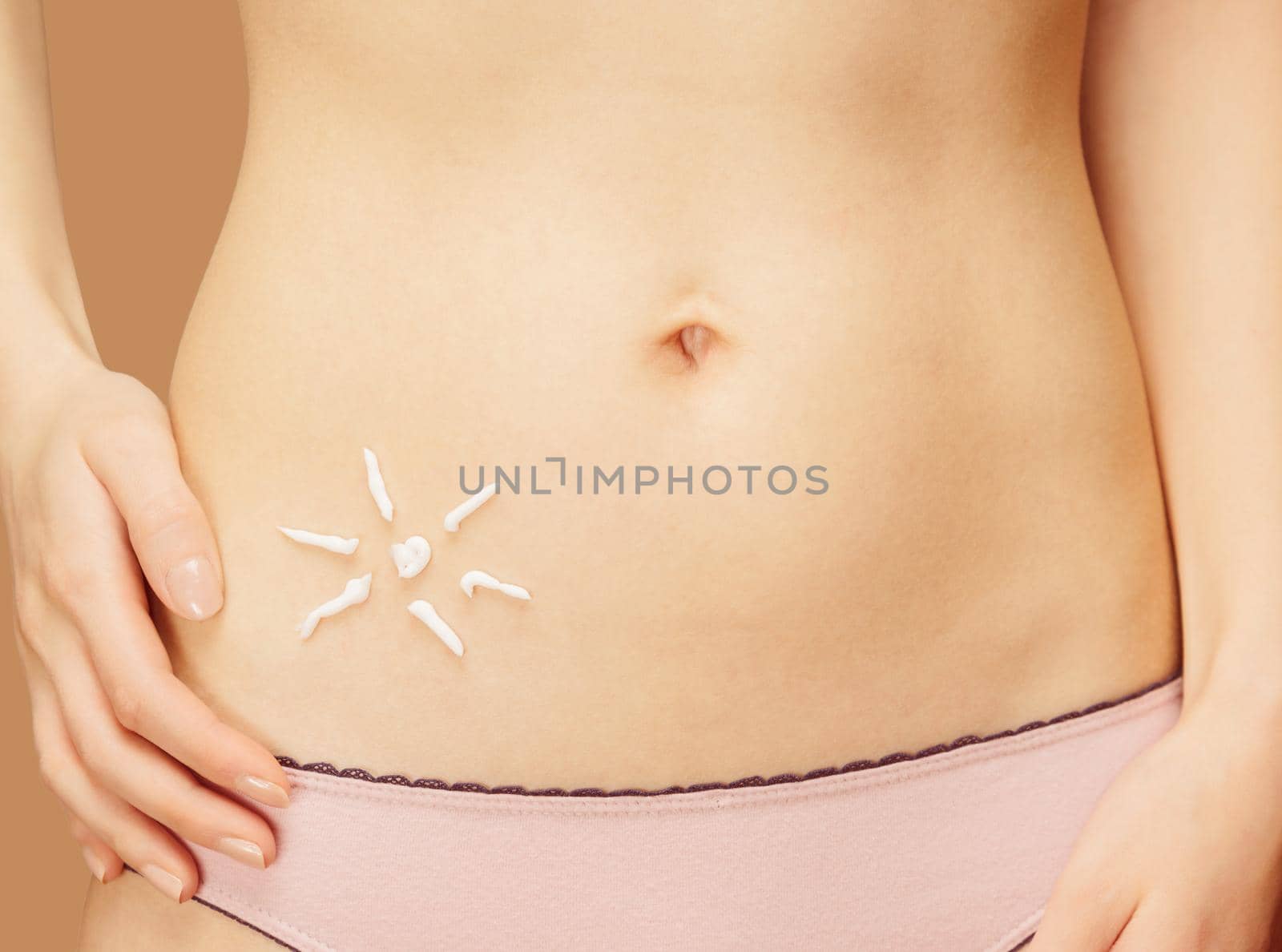 Cream in the form of sun on the skin of the belly, concept of skincare