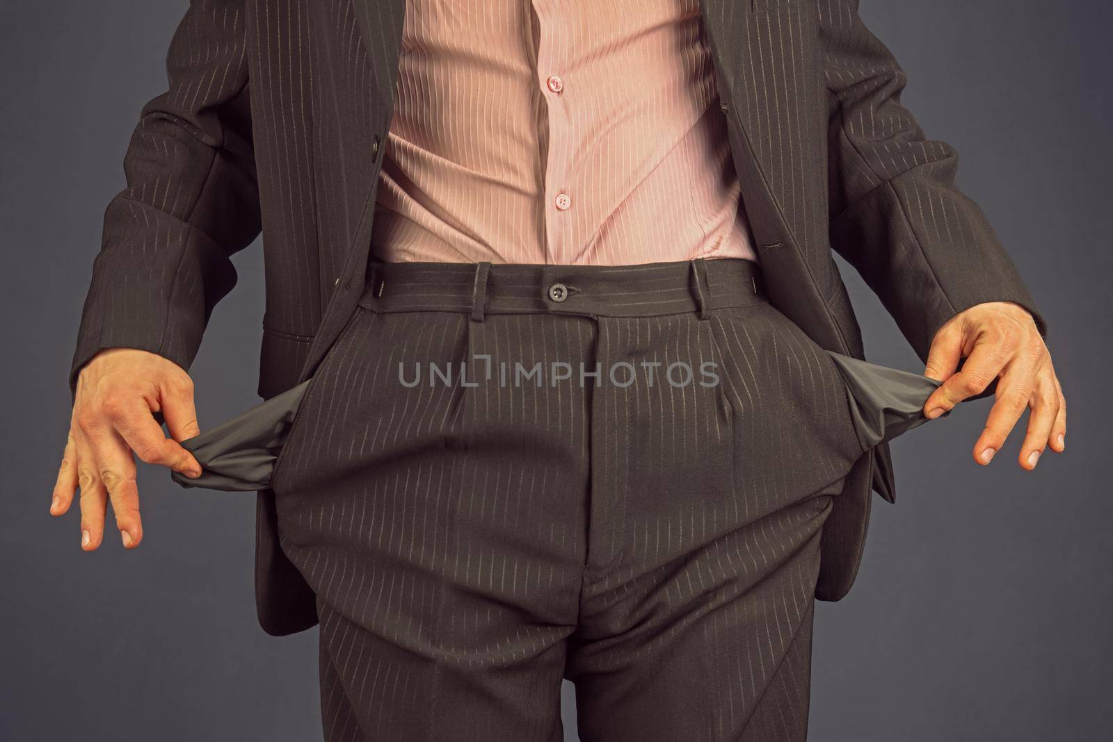 Unrecognizable man in a suit with empty pocket turned inside out