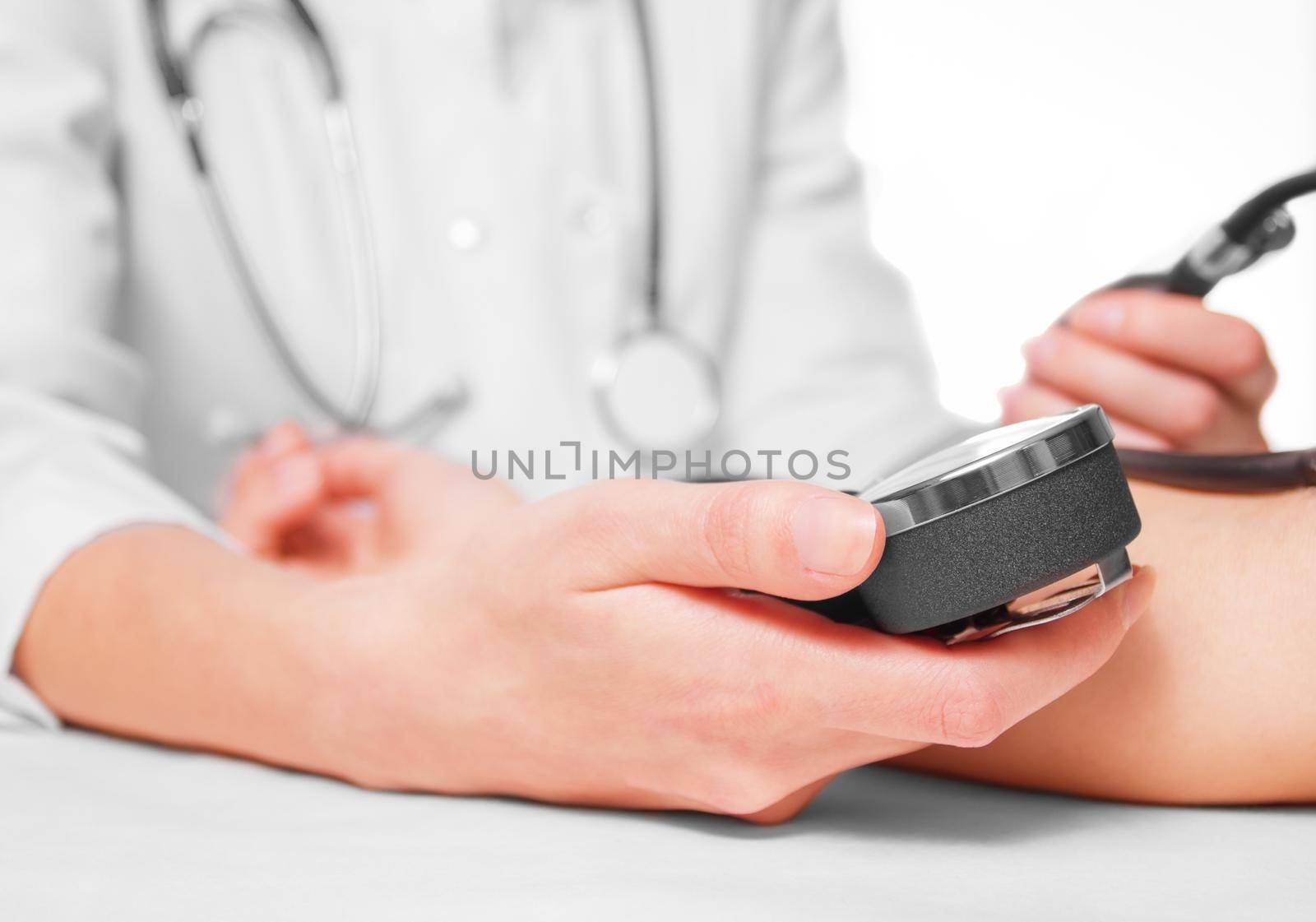 Unrecognizable doctor measures blood pressure a patient, side view