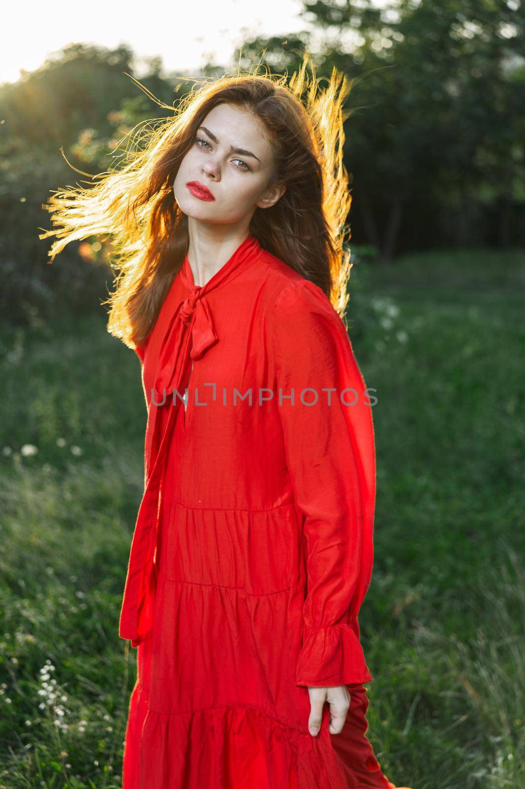 attractive woman in red dress outdoors in freedom field. High quality photo