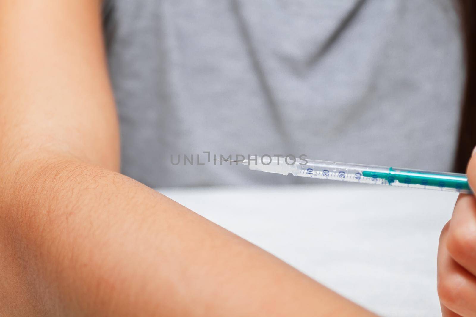 Young woman injects a drug through a syringe
