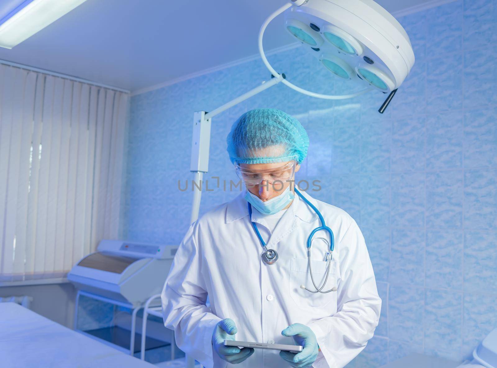 Man doctor surgeon works on a tablet computer in hospital