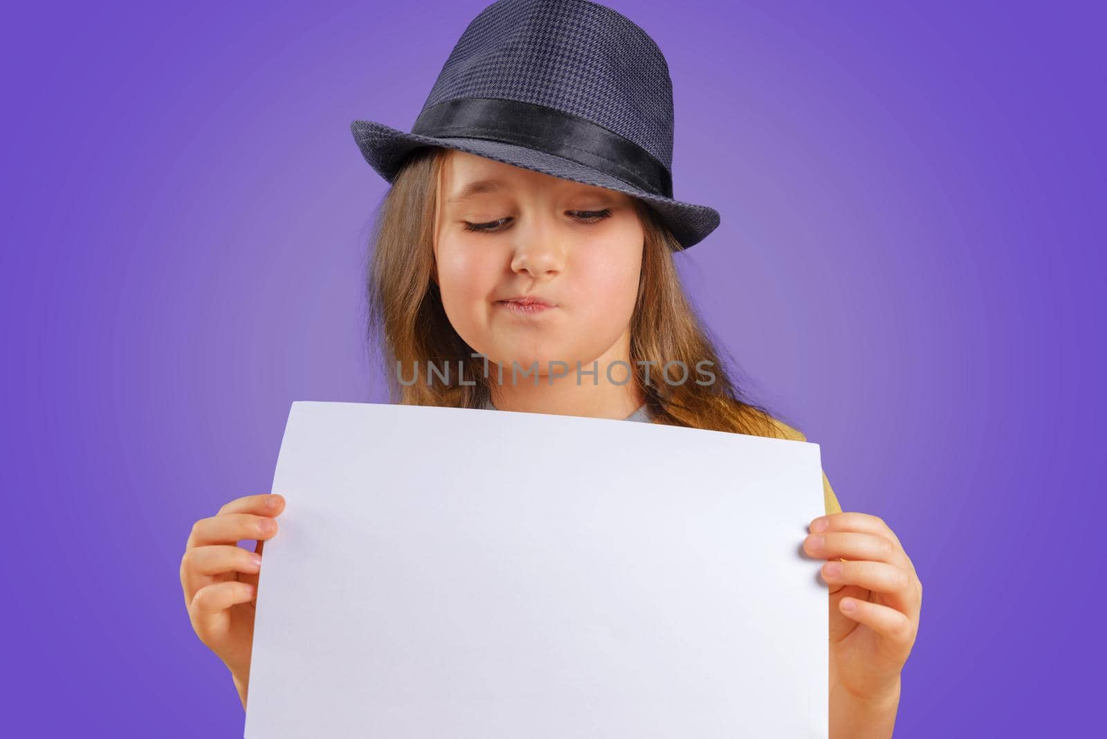 Cute little girl holds blank paper, space for text
