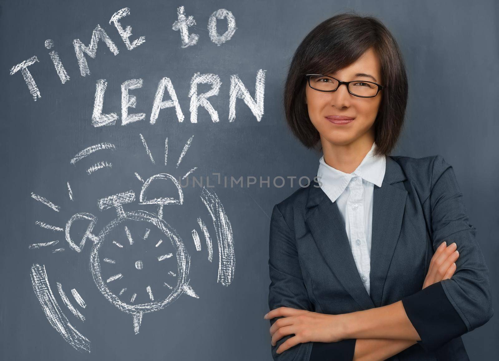 Young woman stands near blackboard with text time to learn