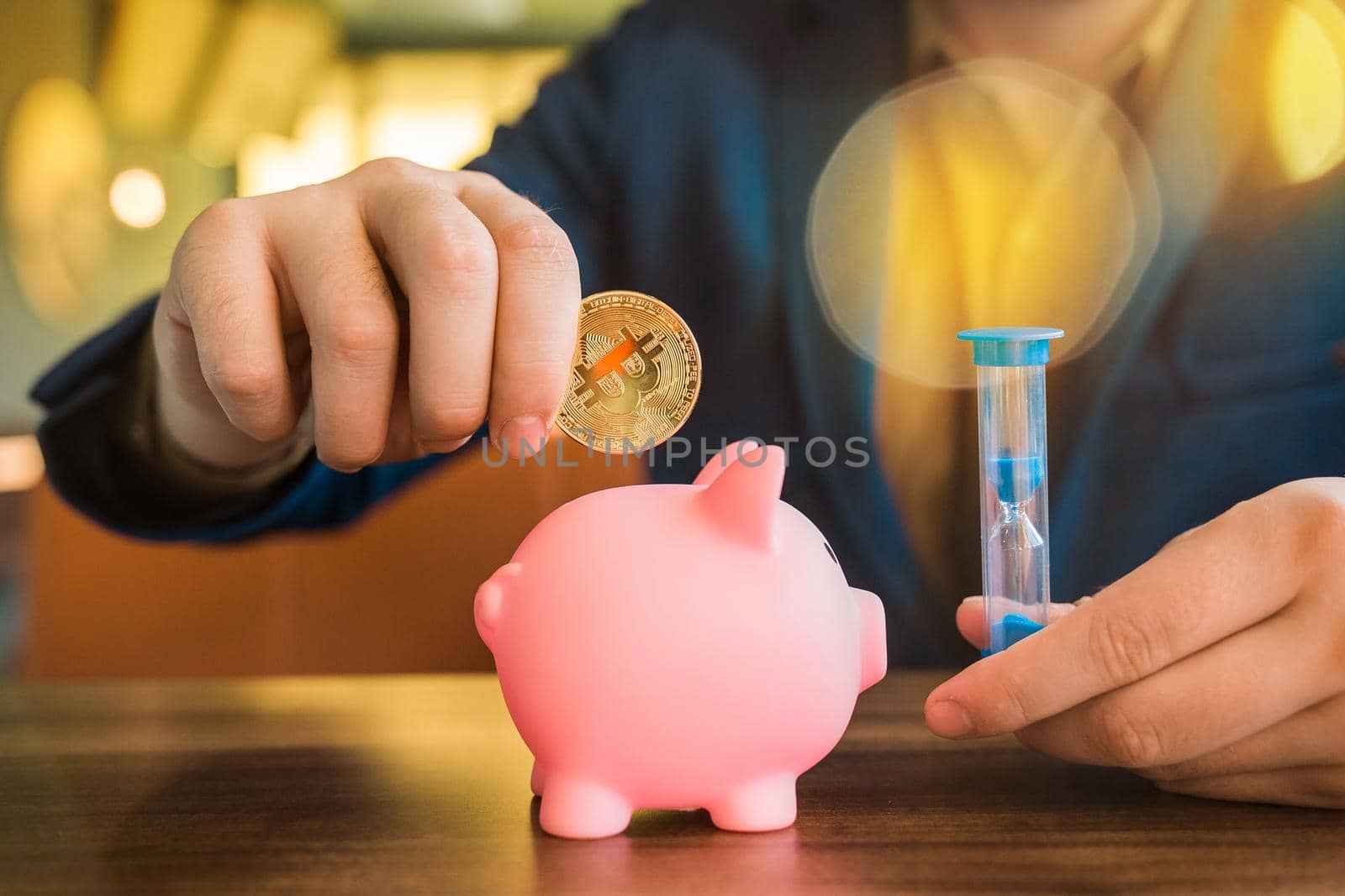 Businessman hands hold gold bitcoin cryptocurrency and hourglass next to pig piggy bank on the table. Bitcoin and cryptocurrency concept.