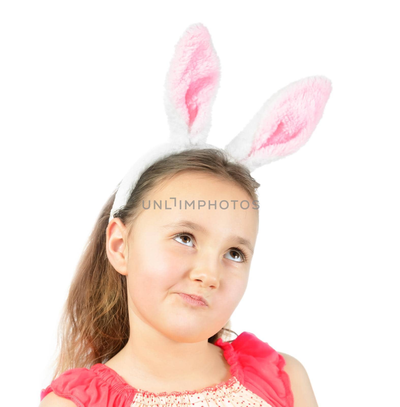 Cute little girl dressed in Easter bunny ears thinks about holiday