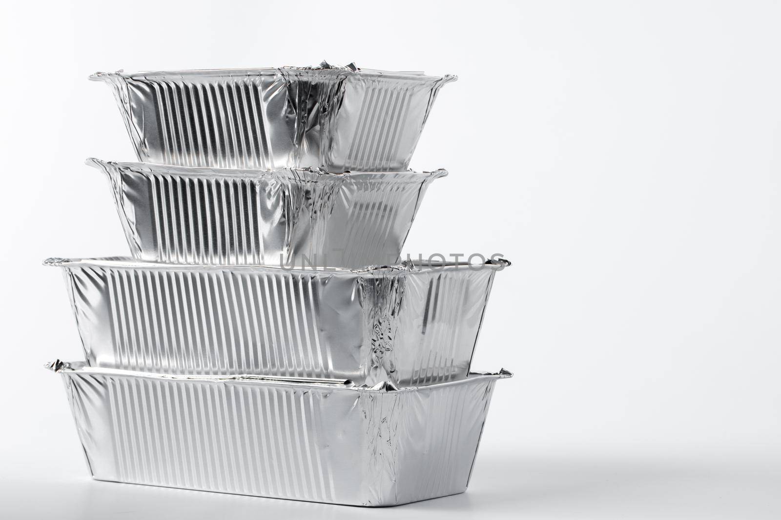 Takeaway meal in foil food box on white background close up