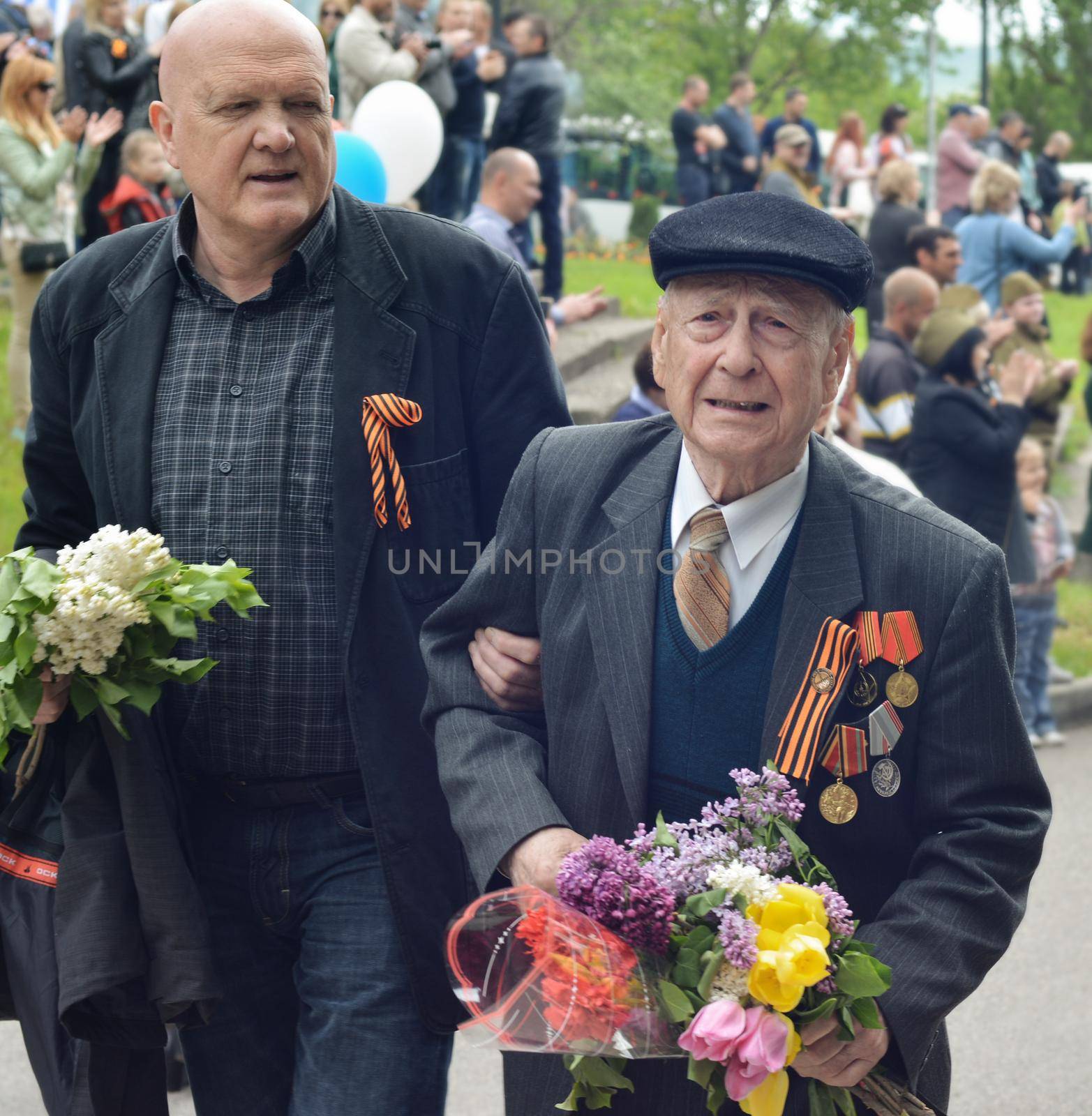 PYATIGORSK, RUSSIA - MAY 09, 2017: The son supports the elderly father on Victory Day by Godi