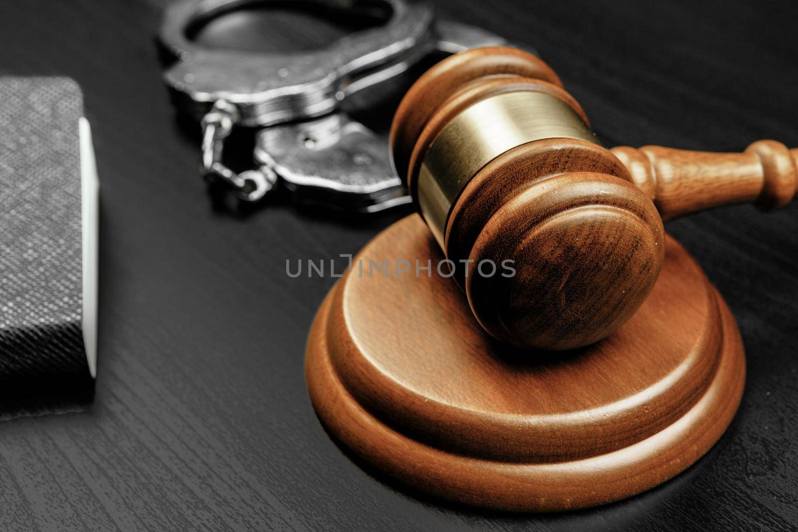Judge gavel with handcuffs on wooden table. Close up.