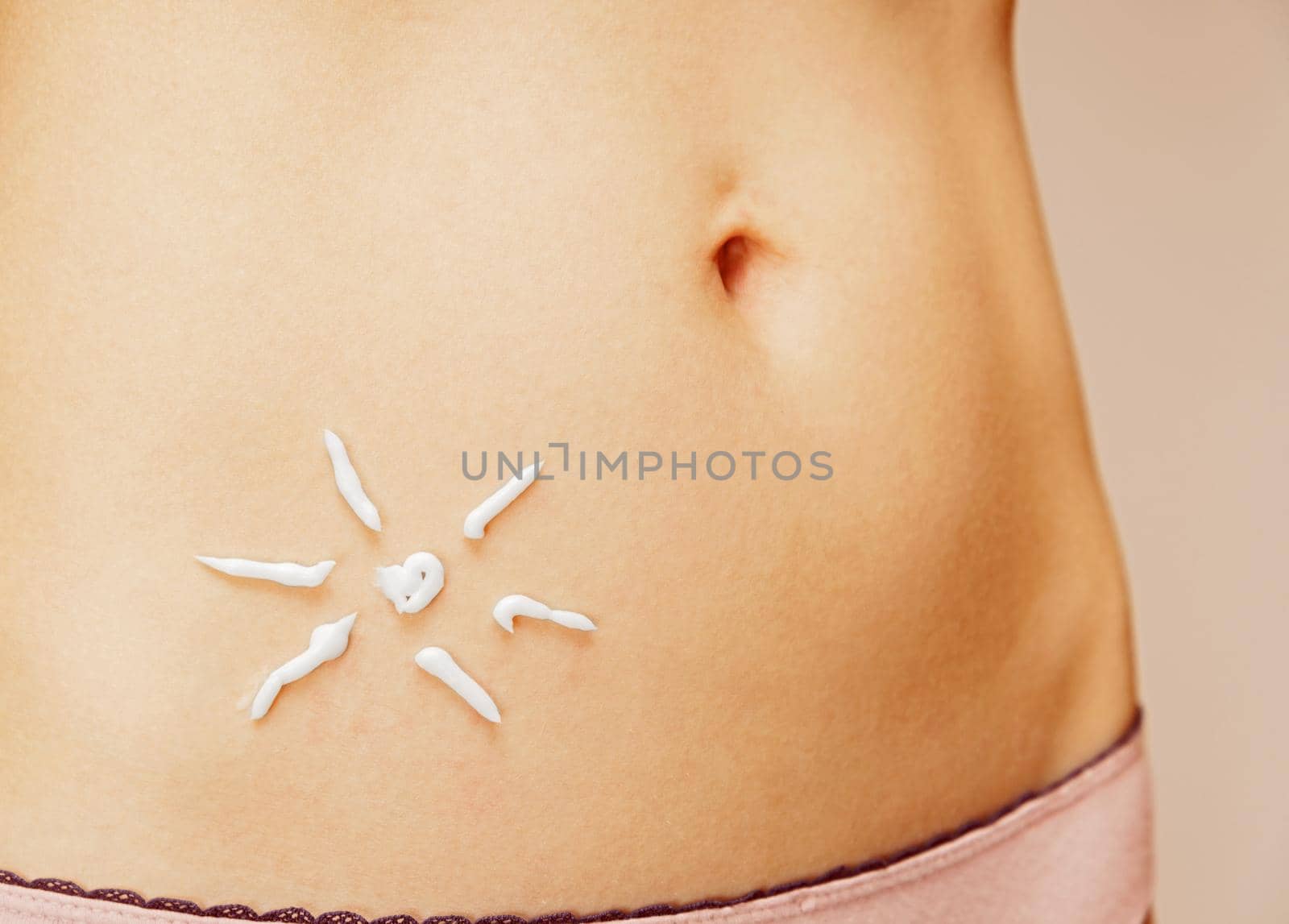Cream in the form of sun on the skin of the abdomen, concept of skincare