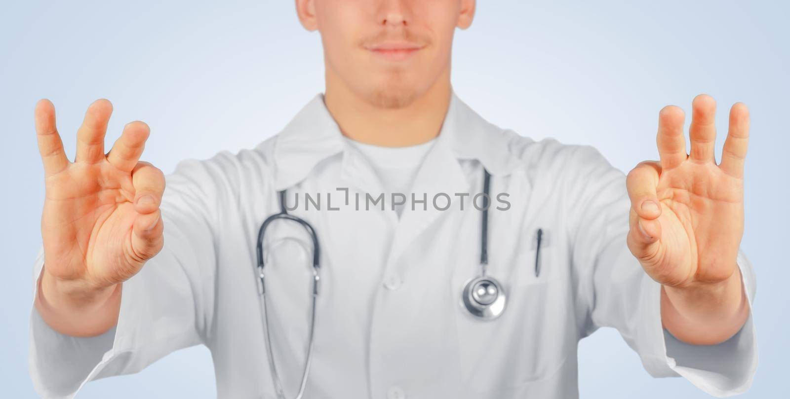 Man doctor holds something in the air, space for text