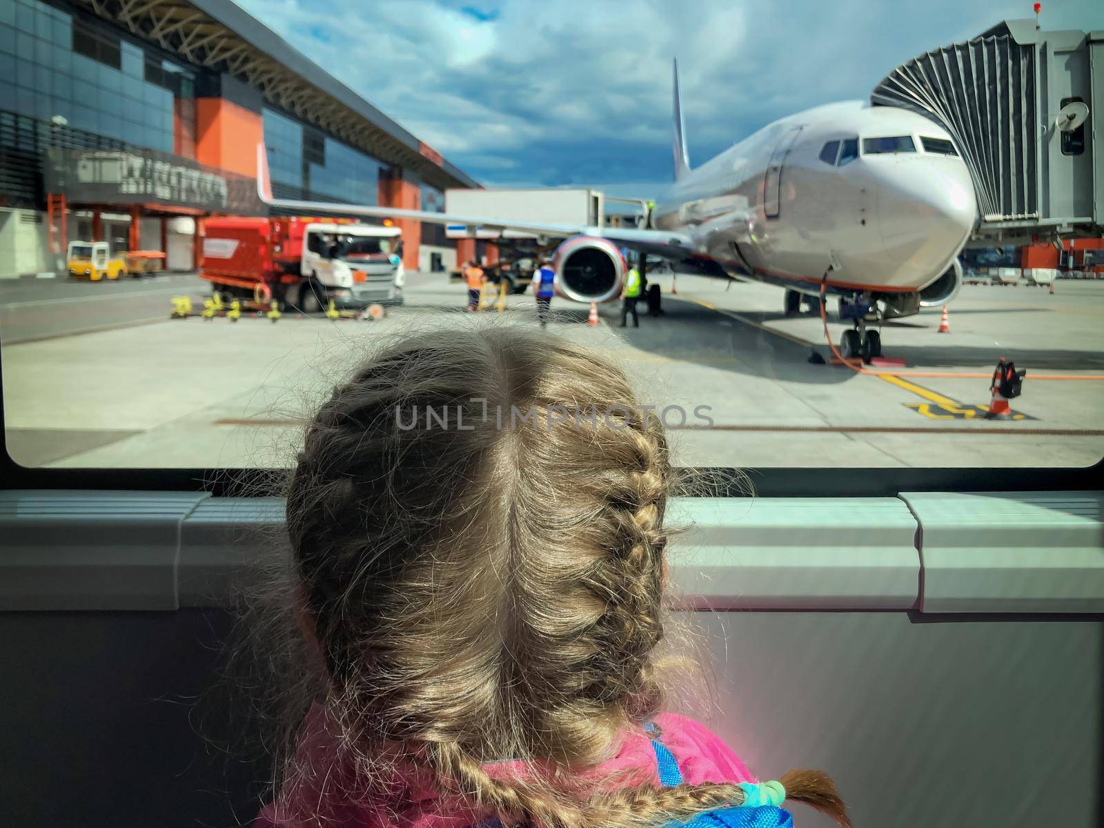 Image of a girl at airport looking at airplane