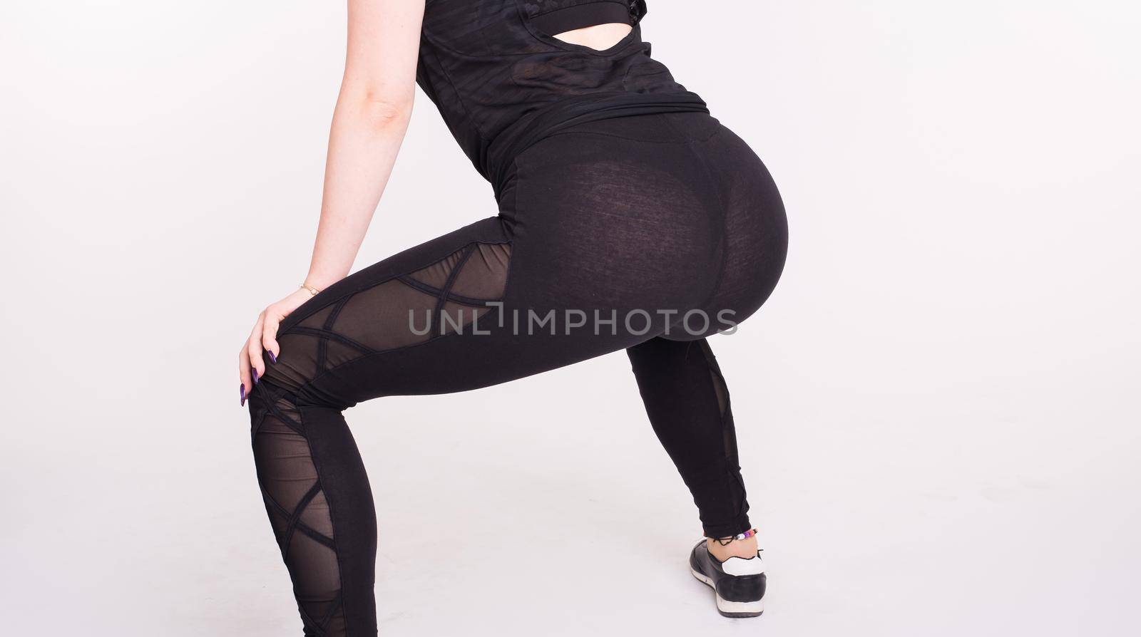 Close-up of girl dancing twerk in the dance class on white background.