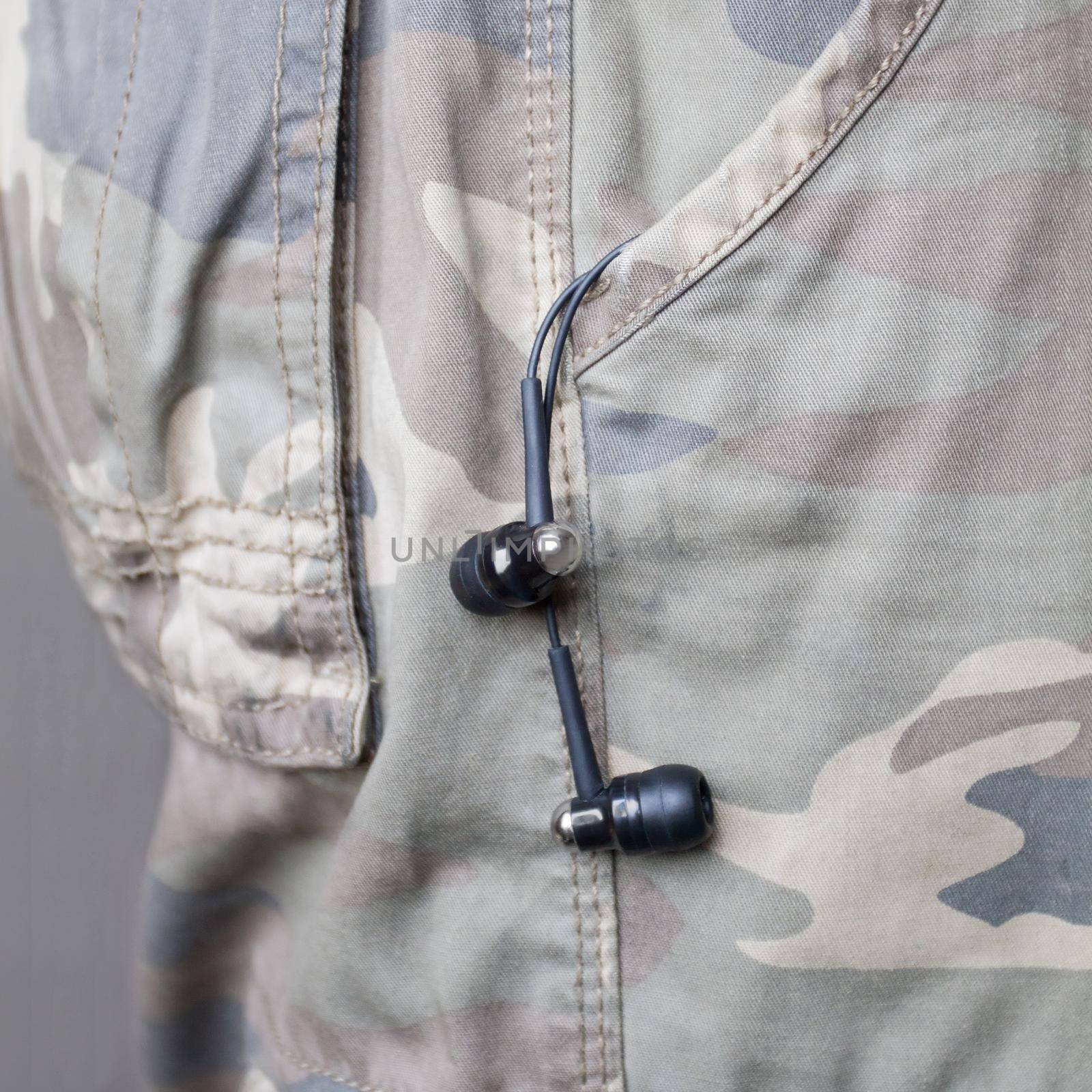 Headphones hanging off a pocket military pants