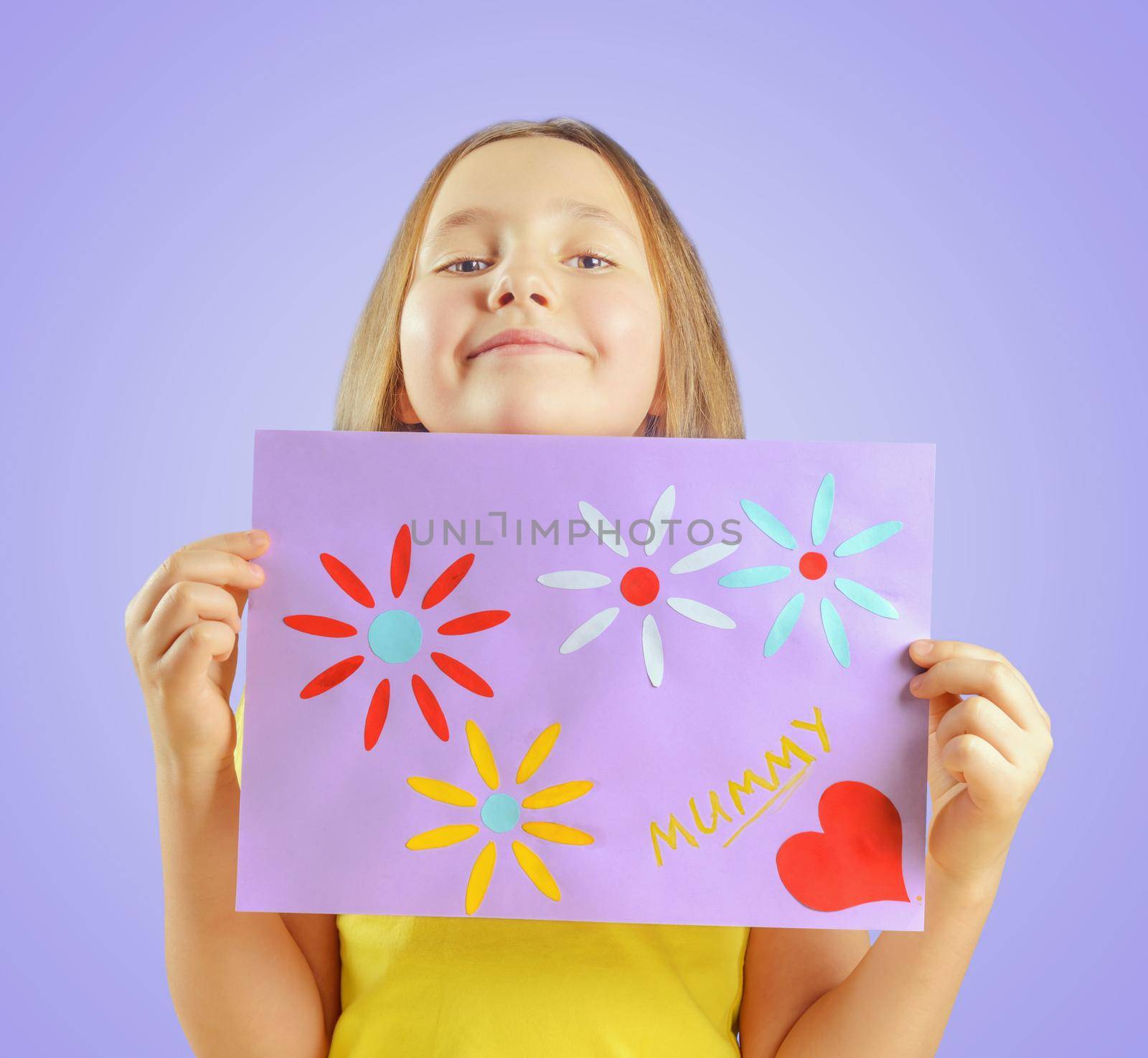 Happy little girl is showing greeting card for mothers day
