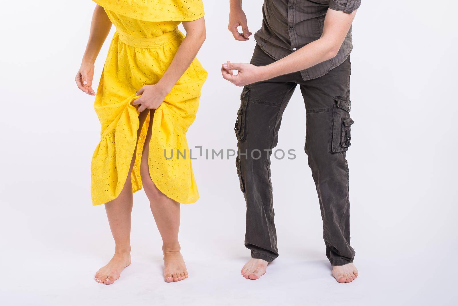 dancing latin music. Bachata, merengue, salsa and kizomba. Close-up of legs elegance pose on white room.