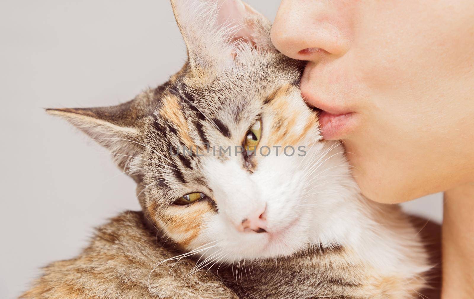 Happy woman kisses orange tabby cat