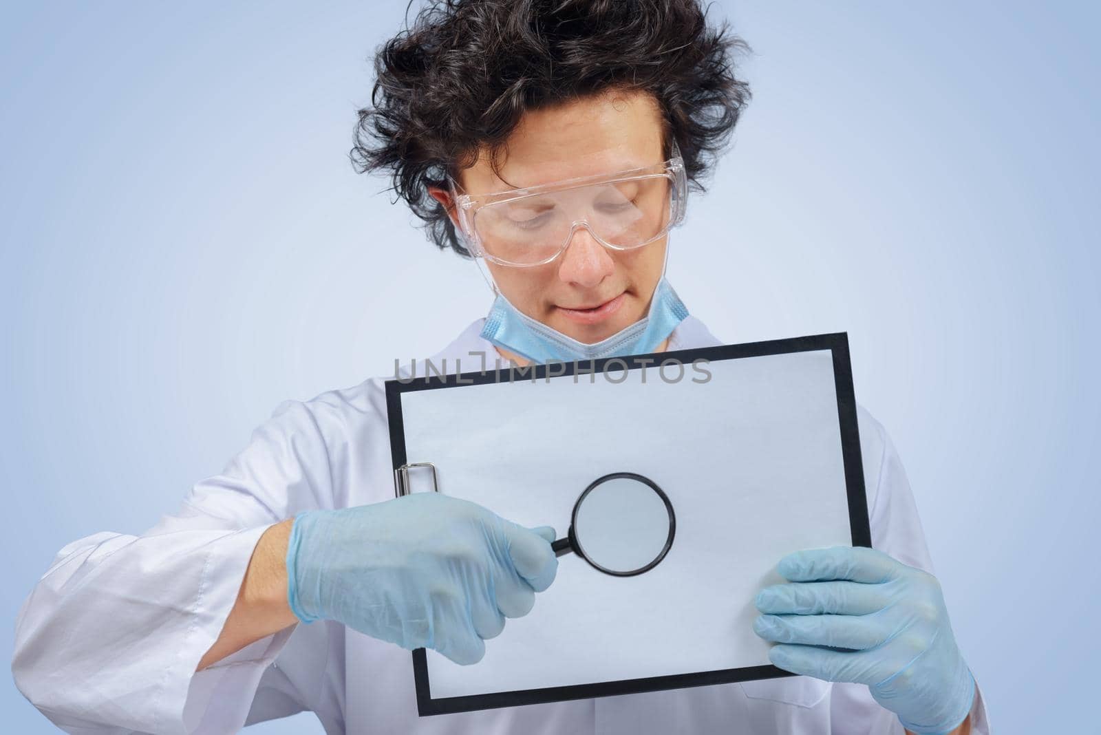 Funny man doctor holds clipboard and magnifying glass