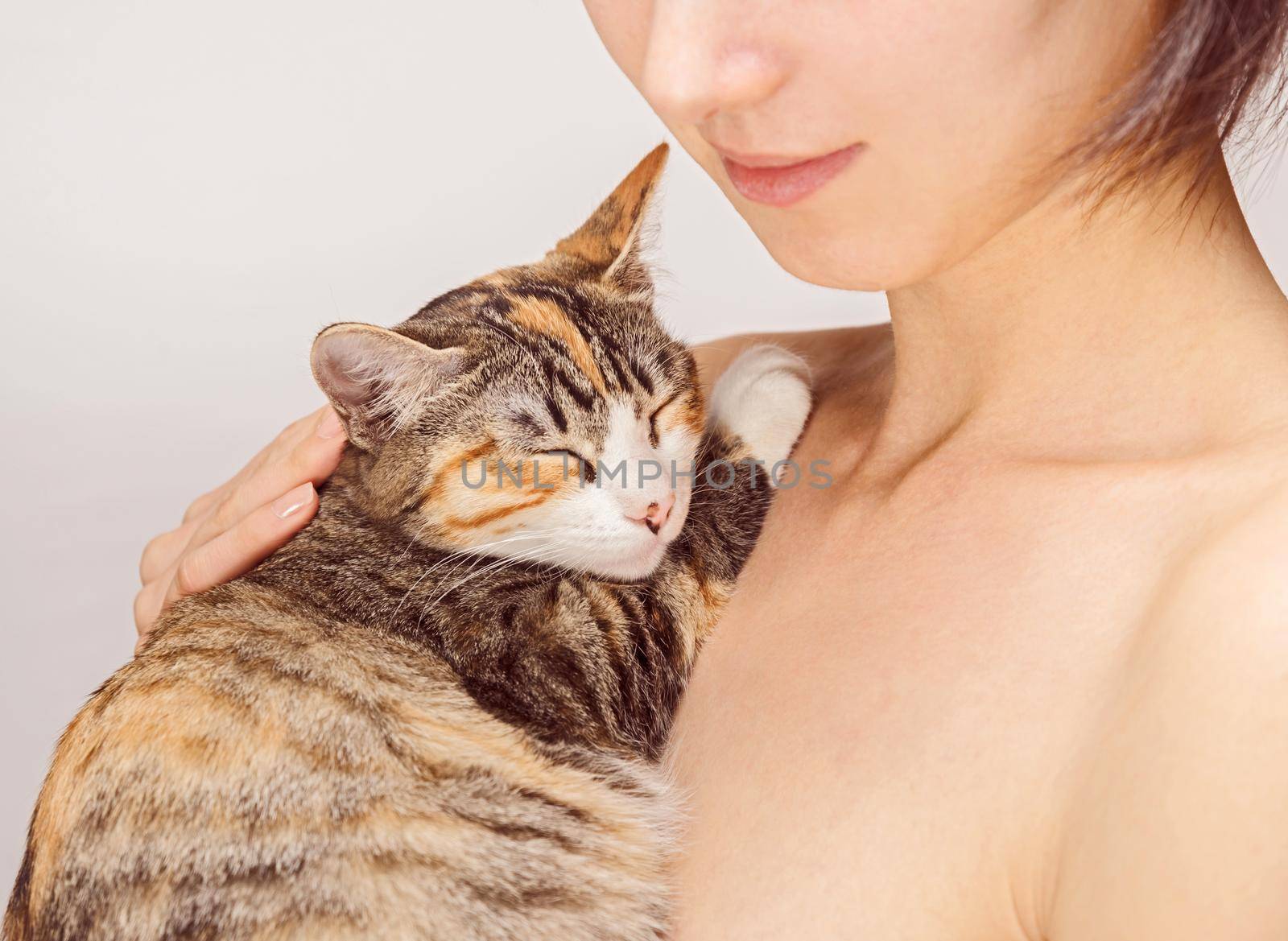 Smiling woman holds cute tabby cat