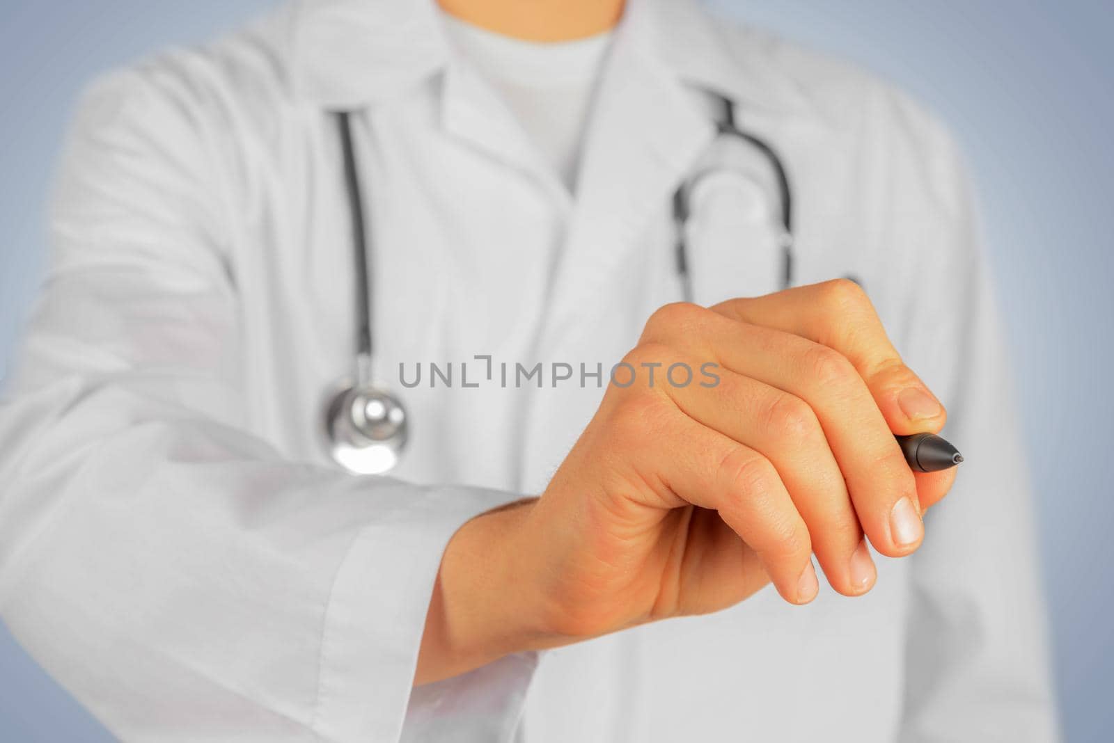 Unrecognizable man doctor is writing with pen something in the air, copyspace