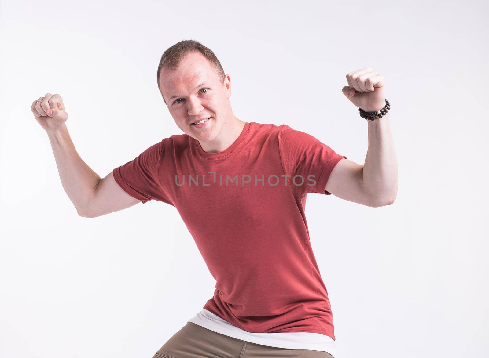 Attractive young man dancing, having fun on white background. Stylish outlook. by Satura86