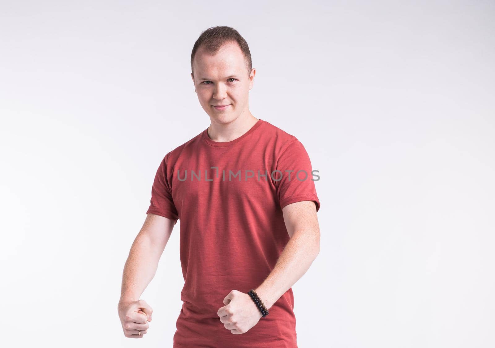 Attractive young man dancing, having fun on white background. Stylish outlook
