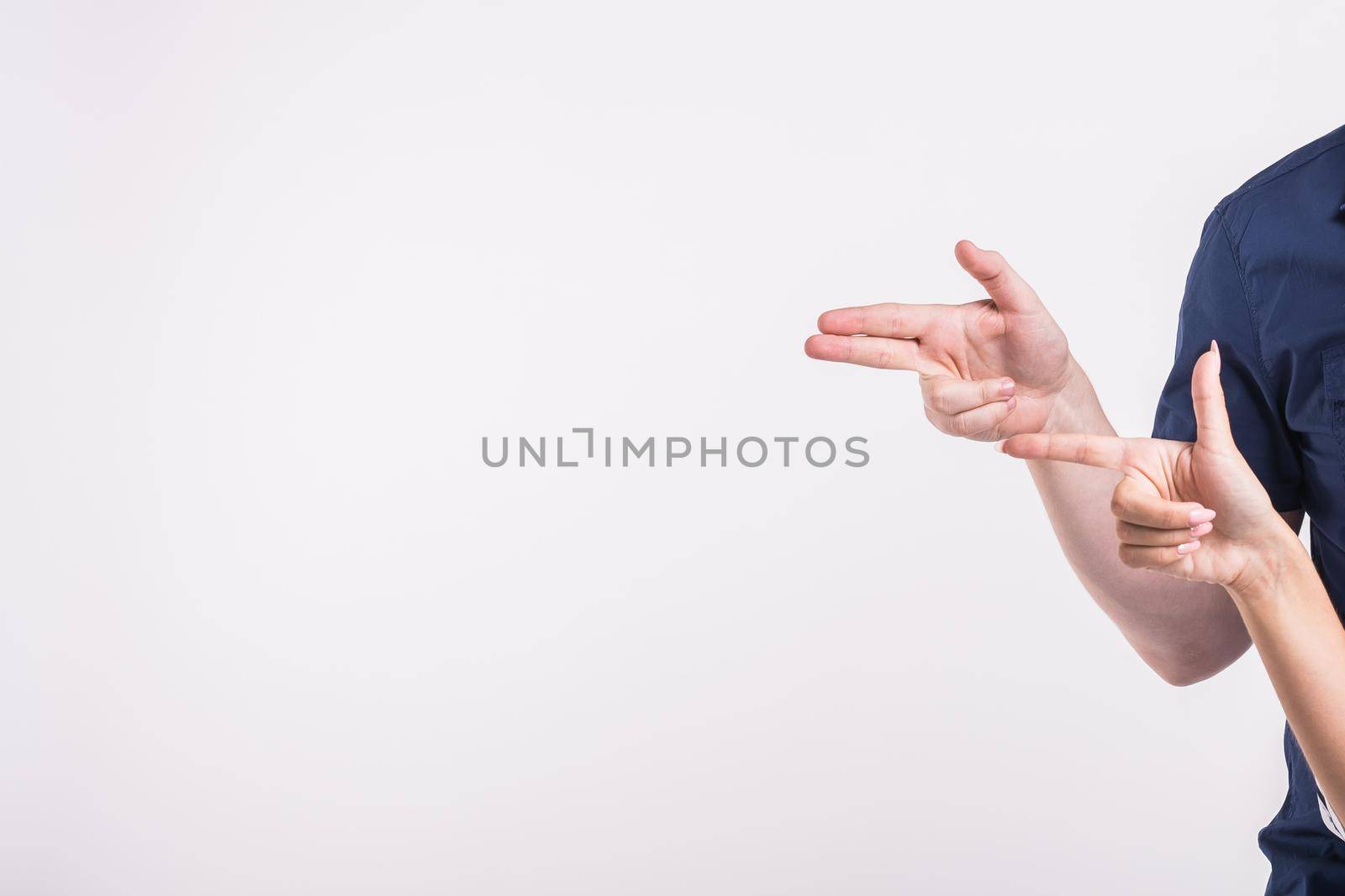 Couple pointing at the left corner with fingers standing isolated over white background. Copy space for product advertisement. by Satura86