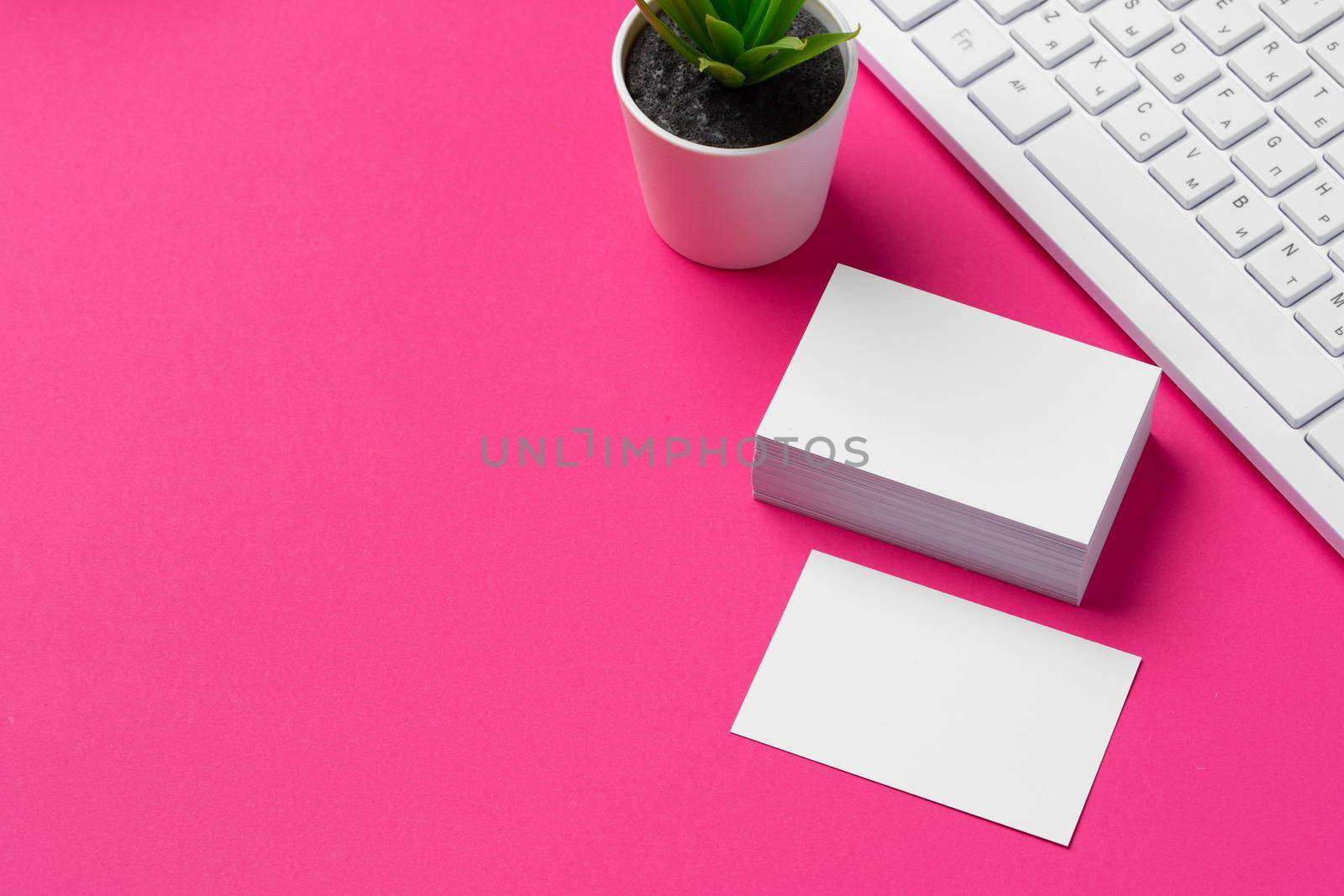 Blank business cards with supplies and keyboard on office table. Close up.