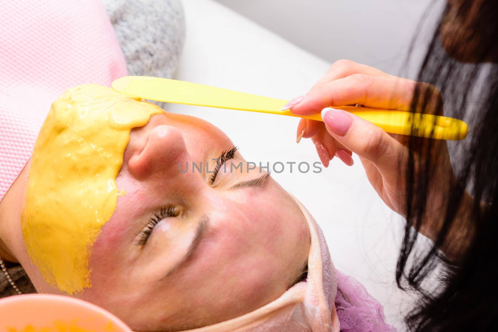 Applying a golden mask on the face after the cleansing procedure, an aromatic mask to moisturize, rejuvenate and lighten the skin. new