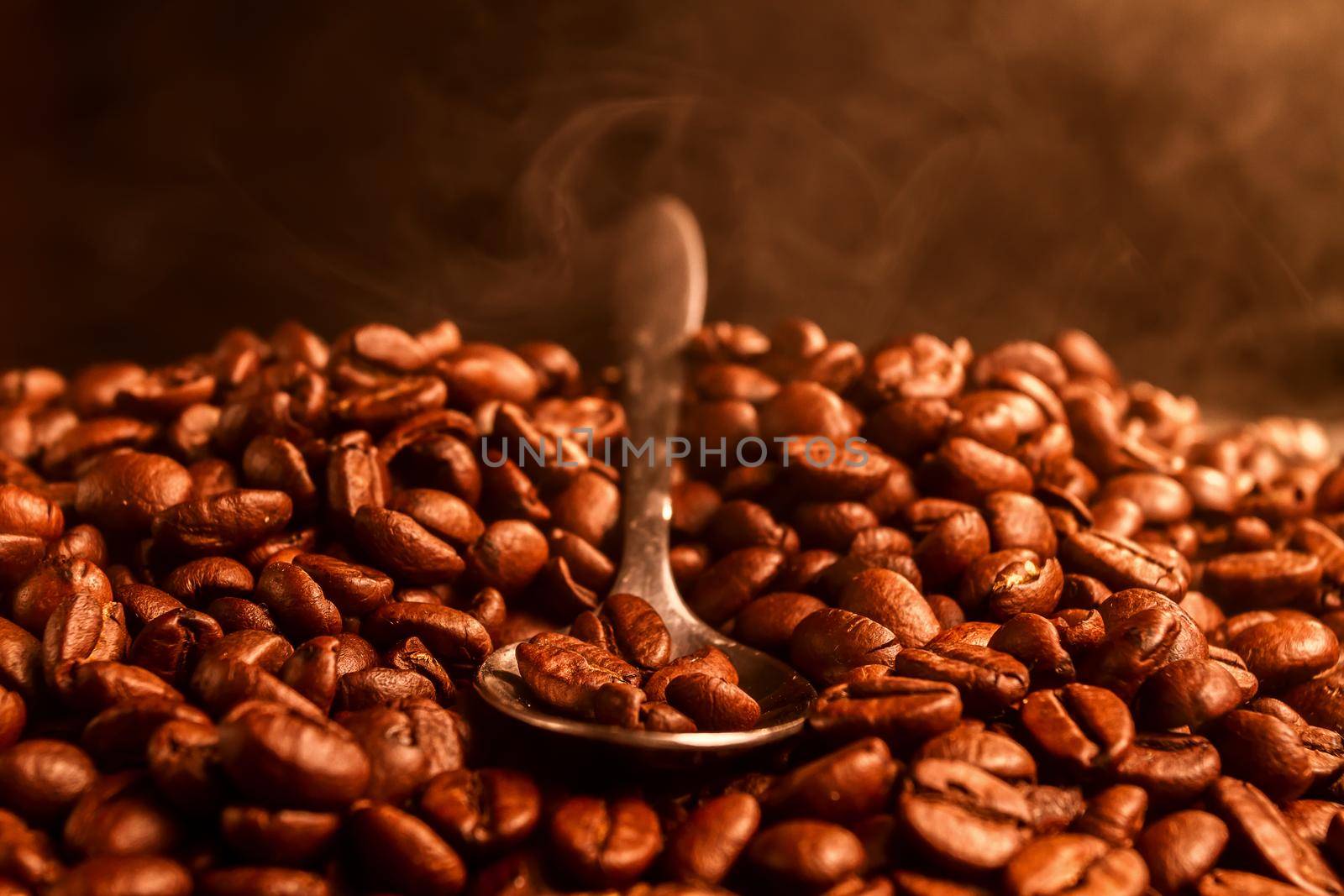 Fragrant fried coffee beans with the smoke, close-up