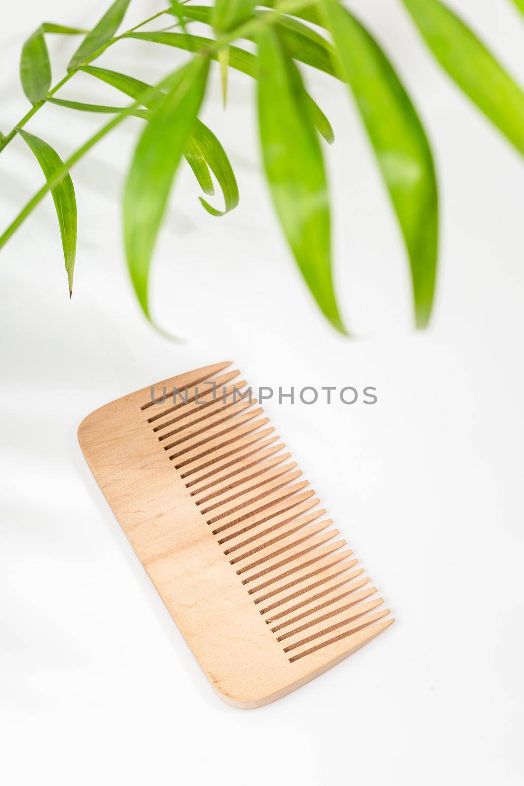 Wood comb on white background. Hairdressing tools, hair comb, eco friendly material
