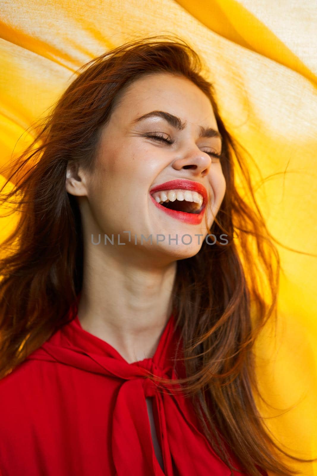 cheerful woman in red dress makeup yellow cloth posing. High quality photo