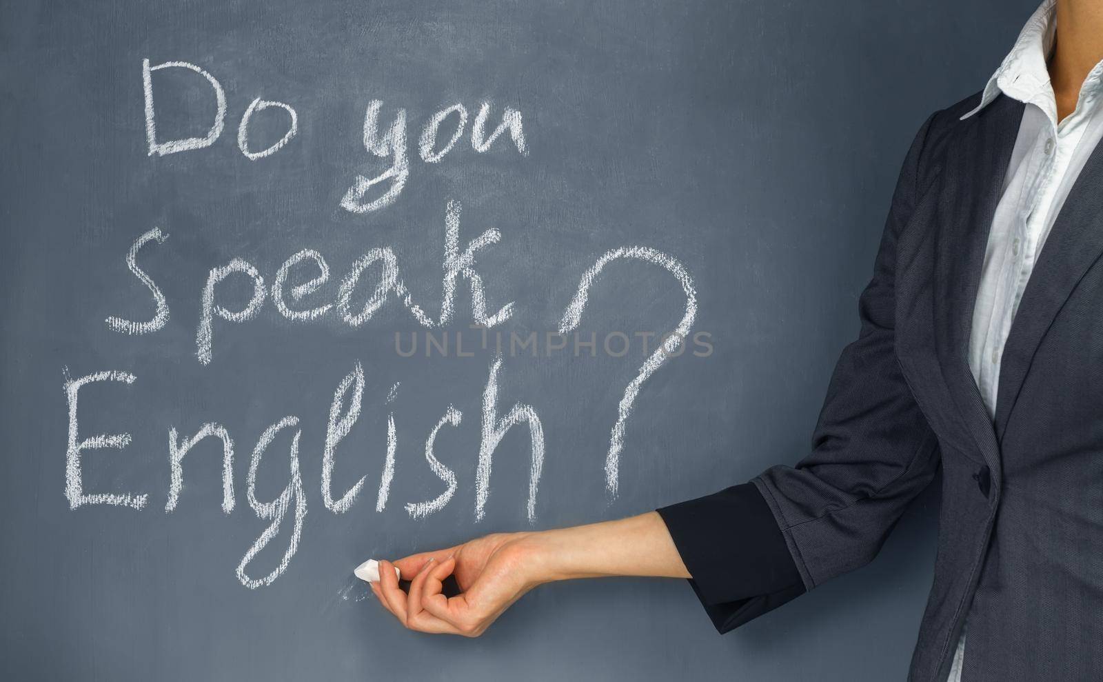 Unrecognizable teacher points to the phrase “Do you speak English?”
